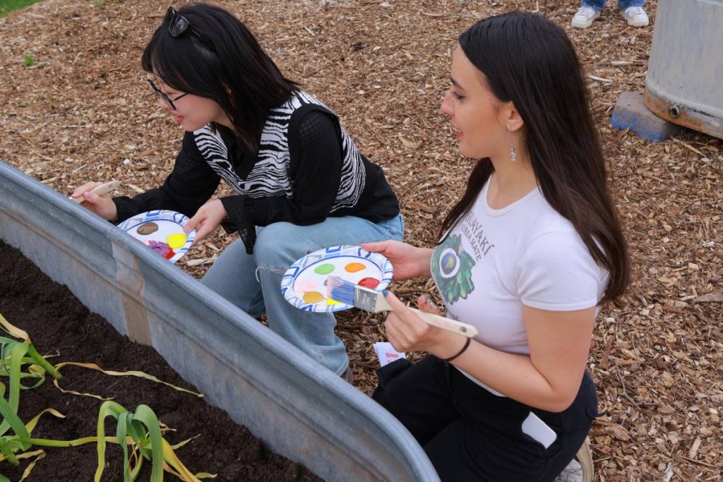 UW students paint a garden bed at the Rainier Community Center Garden in Seattle on Earth Day.